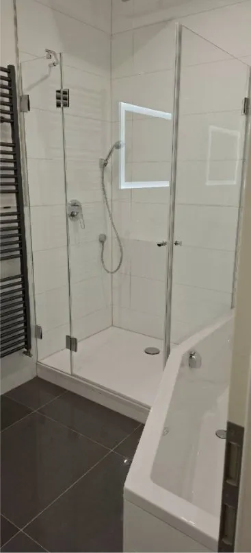 New bathroom with glass shower after post-construction cleaning, no building dust